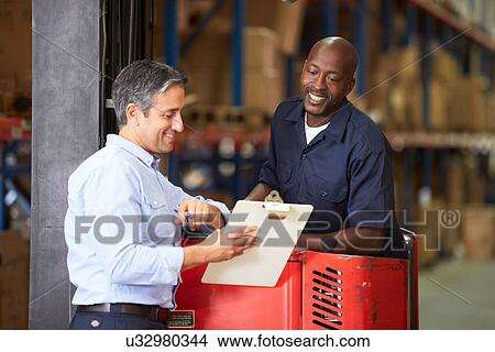 Picture - Fork Lift Truck Operator Talking To Manager In Warehouse. Fotosearch