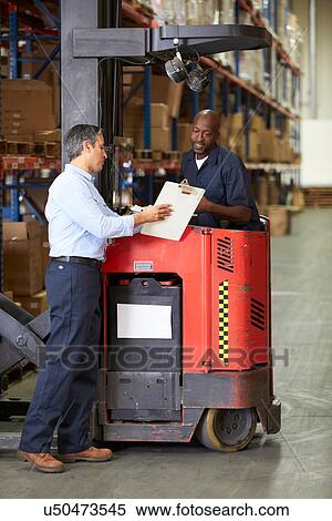 Stock Photography - Fork Lift Truck Operator Talking To Manager In Warehouse. Fotosearch