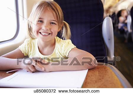 Stock Image - Girl Drawing Picture On Train Journey. Fotosearch