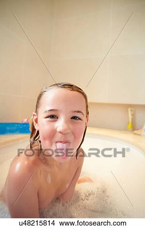 Picture - Girl In Bath Sticking Out Tongue. Fotosearch