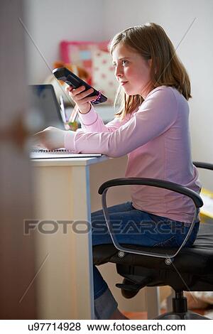 Girl Sitting At Desk In Bedroom With TV Remote Control View Large Photo Image Stock Photo - Girl Sitting At Desk In Bedroom With TV Remote Control. Fotosearch