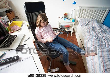 Stock Photo - Girl Using Digital Tablet In Bedroom. Fotosearch