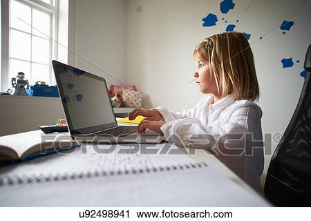 Stock Image - Girl Using Laptop In Bedroom. Fotosearch