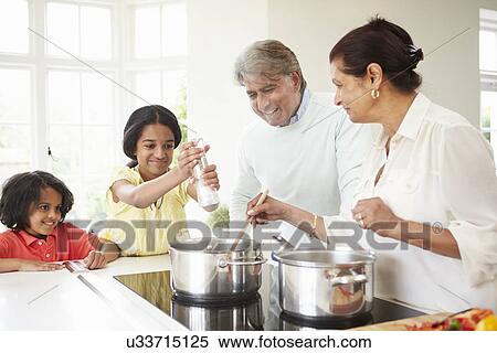 Stock Photography - Grandparents And Grandchildren Cooking Meal At Home. Fotosearch