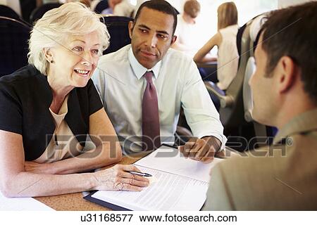 Stock Photo - Group Of Businesspeople Having Meeting On Train. Fotosearch