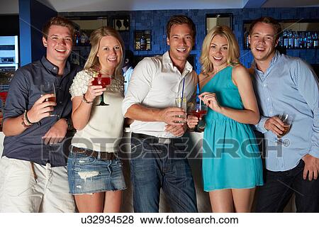 Group Of Friends Enjoying Drink In Bar View Large Photo Image Stock Photo - Group Of Friends Enjoying Drink In Bar. Fotosearch