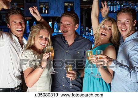 Group Of Friends Enjoying Glass Of Champagne In Bar View Large Photo Image Stock Photo - Group Of Friends Enjoying Glass Of Champagne In Bar. Fotosearch