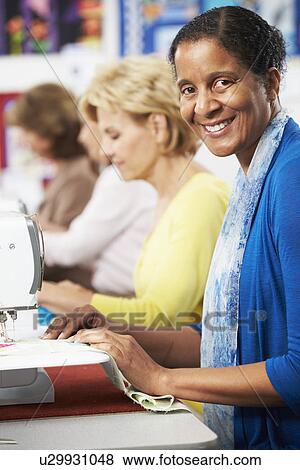 Group Of Women Using Electric Sewing Machines In class View Large Photo Image Stock Photo - Group Of Women Using Electric Sewing Machines In class. Fotosearch