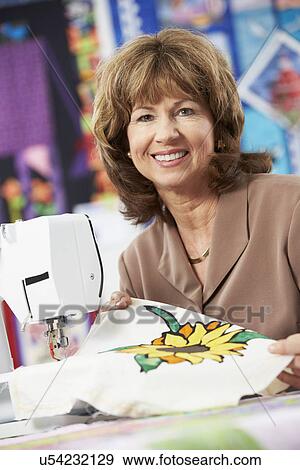 Stock Photo - Group Of Women Using Electric Sewing Machines In class. Fotosearch