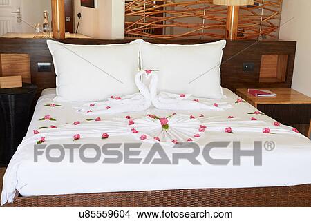 Picture - Hotel Bedroom With Flowers Arranged On Sheets. Fotosearch