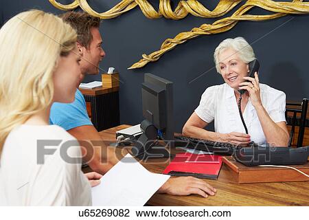 Hotel Receptionist Helping Couple To Check In View Large Photo Image Stock Image - Hotel Receptionist Helping Couple To Check In. Fotosearch