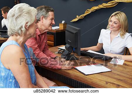Hotel Receptionist Helping Senior Couple To Check In View Large Photo Image Stock Image - Hotel Receptionist Helping Senior Couple To Check In. Fotosearch
