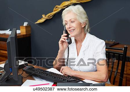 Hotel Receptionist Using Computer And Phone View Large Photo Image Stock Photo - Hotel Receptionist Using Computer And Phone. Fotosearch