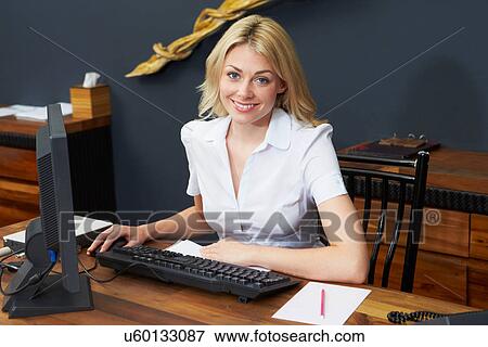 Stock Photo - Hotel Receptionist Working At Computer. Fotosearch
