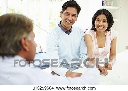 Indian Couple Meeting With Financial Advisor At Home View Large Photo Image Picture - Indian Couple Meeting With Financial Advisor At Home. Fotosearch