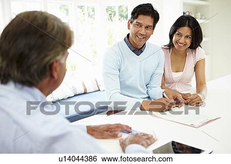 Stock Photograph - Indian Couple Meeting With Financial Advisor At Home. Fotosearch