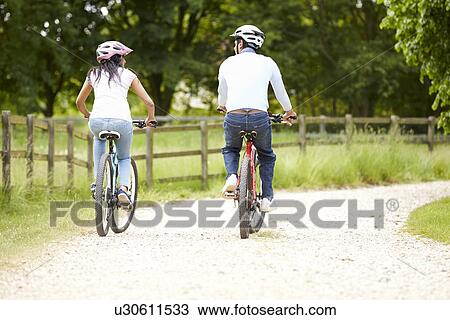 Stock Image - Indian Couple On Cycle Ride In Countryside. Fotosearch
