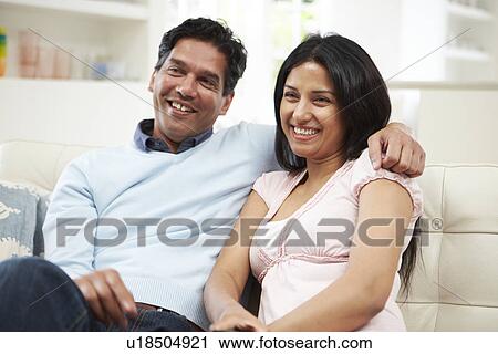 Indian Couple Sitting On Sofa Watching TV Together View Large Photo Image Stock Image - Indian Couple Sitting On Sofa Watching TV Together. Fotosearch