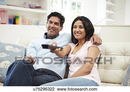 Indian Couple Sitting On Sofa Watching TV Together View Large Photo Image Stock Image - Indian Couple Sitting On Sofa Watching TV Together. Fotosearch