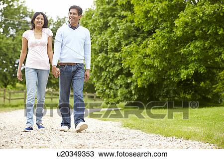 Stock Image - Indian Couple Walking In Countryside. Fotosearch