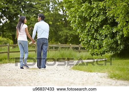 Stock Image - Indian Couple Walking In Countryside. Fotosearch