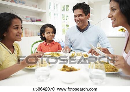 Stock Image - Indian Family Eating Meal At Home. Fotosearch