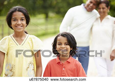 Stock Image - Indian Grandparents And Grandchildren Walking In Countryside. Fotosearch