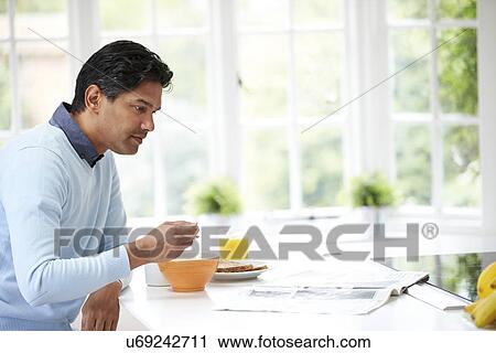 Stock Image - Indian Man Enjoying Breakfast At Home. Fotosearch