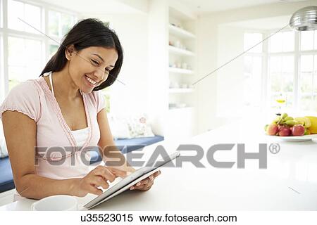 Stock Photography - Indian Woman Using Digital Tablet At Home. Fotosearch