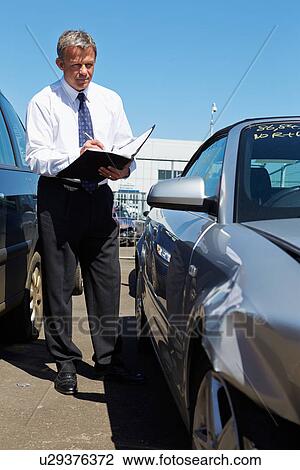 Stock Image - Loss Adjuster Inspecting Car Involved In Accident. Fotosearch