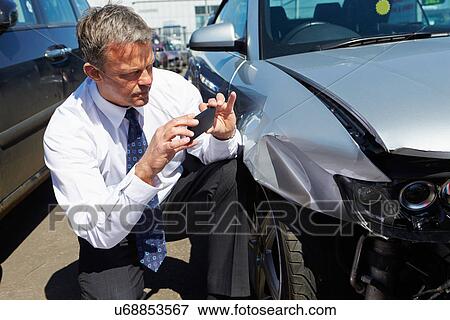Stock Photo - Loss Adjuster Inspecting Car Involved In Accident. Fotosearch