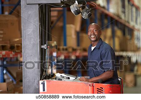 Stock Photo - Man Driving Fork Lift Truck In Warehouse. Fotosearch