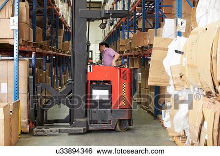 Stock Photograph - Man Driving Fork Lift Truck In Warehouse. Fotosearch