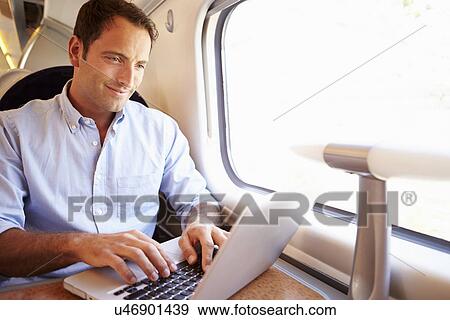 Stock Photo - Man Using Laptop On Train. Fotosearch