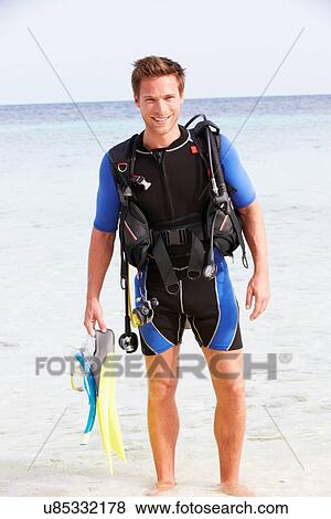 Stock Photo - Man With Scuba Diving Equipment Enjoying Beach Holiday. Fotosearch