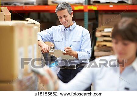 Manager In Warehouse With Worker Scanning Box In Foreground View Large Photo Image Stock Image - Manager In Warehouse With Worker Scanning Box In Foreground. Fotosearch