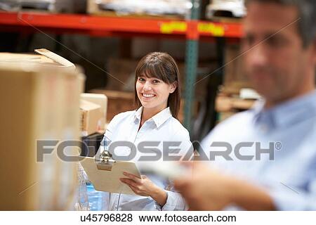 Manager In Warehouse With Worker Scanning Box In Foreground View Large Photo Image Stock Photo - Manager In Warehouse With Worker Scanning Box In Foreground. Fotosearch