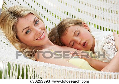 Stock Image - Mother And Daughter Relaxing In Beach Hammock. Fotosearch