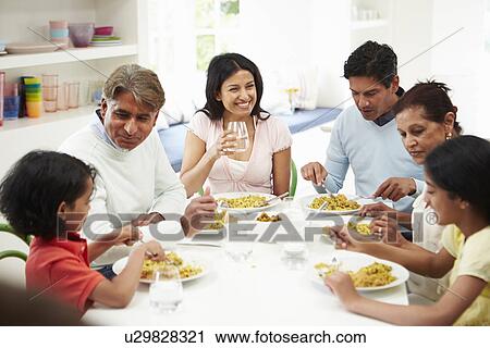 Stock Image - Multi Generation Indian Family Eating Meal At Home. Fotosearch