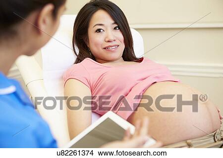 Picture - Nurse Using Digital Tablet In Meeting With Pregnant Woman. Fotosearch