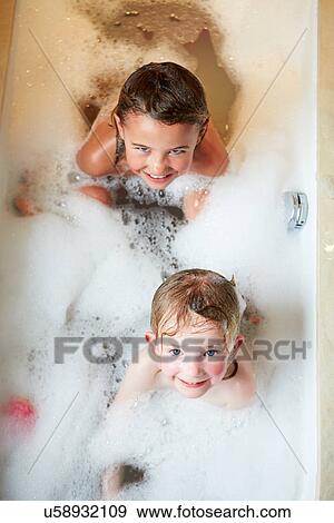Stock Photo - Overhead View Of Two Girls In Bath. Fotosearch