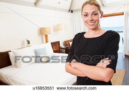 Stock Image - Portrait Of Hotel Chambermaid In Guest Room. Fotosearch