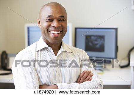 Stock Image - Portrait Of Male Obstetrician In Hospital. Fotosearch