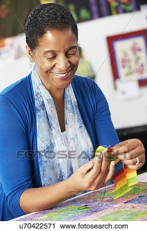 Stock Image - Portrait Of Woman Sewing Quilt. Fotosearch