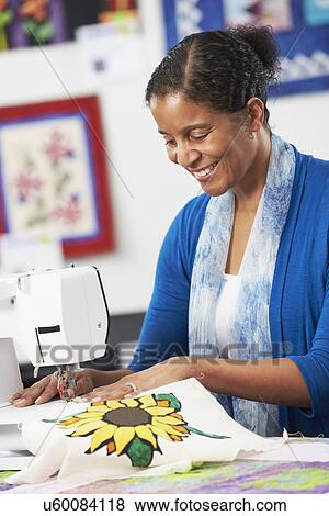 Stock Photo - Portrait Of Woman Using Electric Sewing Machine. Fotosearch