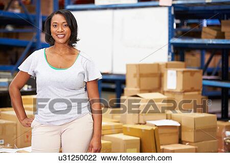 Stock Image - Portrait Of Worker In Distribution Warehouse. Fotosearch