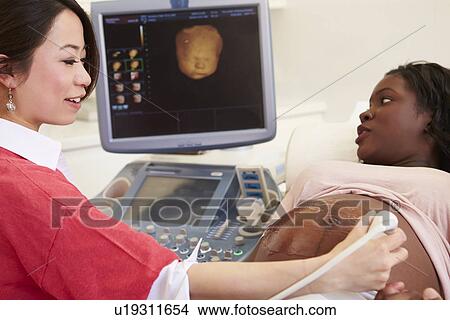Picture - Pregnant Woman And Partner Having 4D Ultrasound Scan. Fotosearch