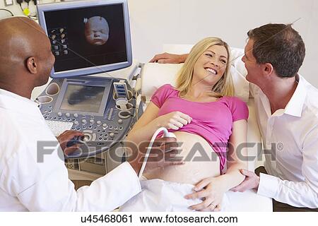 Stock Image - Pregnant Woman And Partner Having 4D Ultrasound Scan. Fotosearch