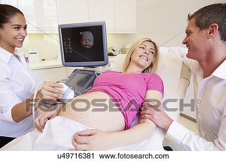 Stock Image - Pregnant Woman And Partner Having 4D Ultrasound Scan. Fotosearch