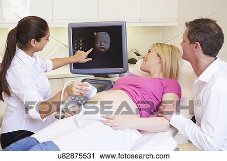 Stock Image - Pregnant Woman And Partner Having 4D Ultrasound Scan. Fotosearch